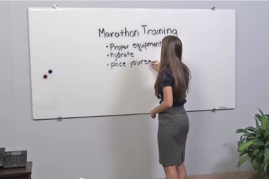 Woman Writing on Large Glass Dry Erase Board